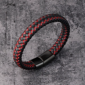 Macro shot of a braided black leather bracelet featuring distinctive red stitching details