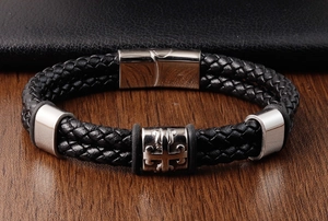 Close-up of black braided leather men's bracelet with stainless steel cross magnetic clasp