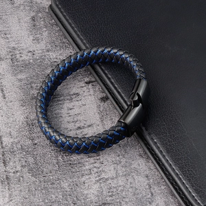 Detail of men's braided black leather bracelet with blue stitching and magnetic clasp