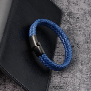 Detail of blue braided leather bracelet featuring a black matte metal puzzle clasp closure