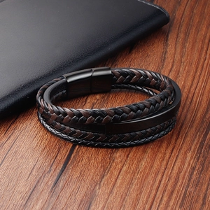 Men's multilayer braided leather bracelet with black magnetic clasp on wood surface