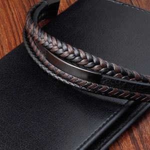 Detail of multi-layer braided leather bracelet with black brushed metal insert and clasp