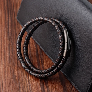 Men's double-layered braided leather bracelet with gunmetal steel clasp on wooden background