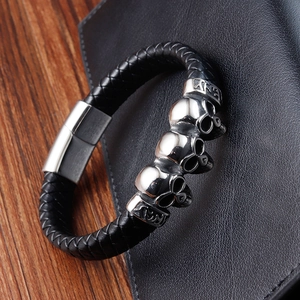 Punk black leather braided bracelet featuring silver skull charms and magnetic clasp