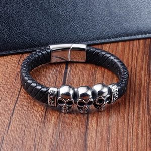 Men's punk black braided leather bracelet featuring vintage silver skull charms and magnetic clasp