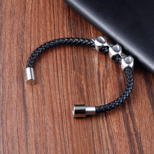 Punk woven leather skull bracelet for men with magnetic clasp on wooden background