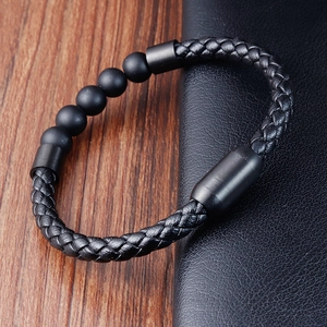 Detail of men's leather braided bracelet with volcanic stone beads and magnetic clasp