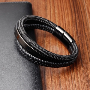 Dettaglio macro del bracciale in pelle intrecciata nera con chiusura magnetica nera