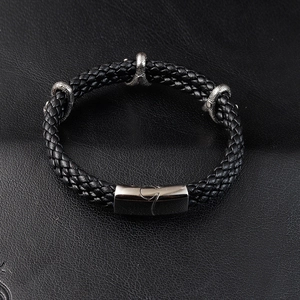 Vue détaillée du bracelet en cuir tressé noir avec trois breloques griffes de dragon en argent