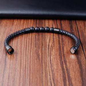 Detail of multi-layer black braided leather bracelet with lava stones and magnetic clasp