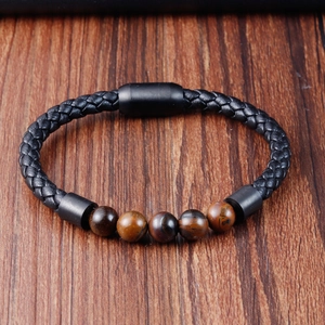 Detail of multi-layer black braided leather bracelet with tiger eye beads and magnetic clasp