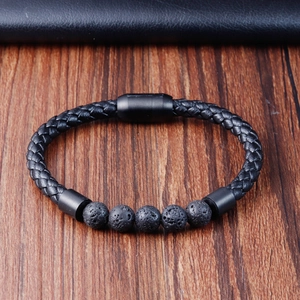 Macro shot of men's leather braided bracelet with volcanic stones on a wood surface