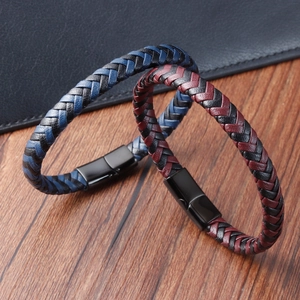 Détail de bracelets en cuir tressé bicolore avec fermoirs magnétiques en métal noir mat