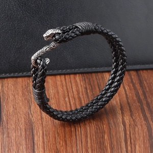Détail d'un bracelet en cuir tressé noir avec fermoir en métal tête de serpent
