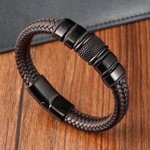 Braided leather bracelet for men with black magnetic clasp on a wooden surface