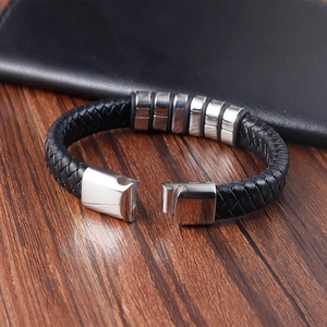 Macro shot of a men's black braided leather bracelet with stainless steel metal accents