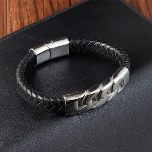 Close-up of men's black braided leather bracelet with brushed metal magnetic buckle