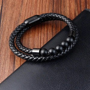 Detail of men's braided leather bracelet with black magnetic clasp and matte stone beads