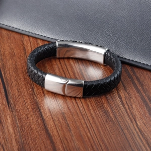 Men's braided leather bracelet with magnetic stainless steel clasp on a wooden desk