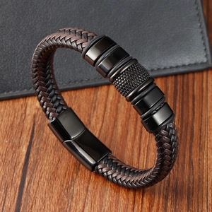 Detail of dark brown braided leather bracelet with black textured metal rings and magnetic clasp