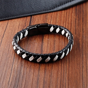 Gros plan d'un bracelet en cuir tressé noir et blanc avec fermoir magnétique en métal