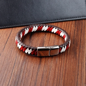 Détail du bracelet en cuir tressé rouge et blanc avec fermoir magnétique en métal poli