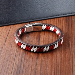 Détail du bracelet tressé en cuir rouge, blanc et marron avec fermoir magnétique argenté