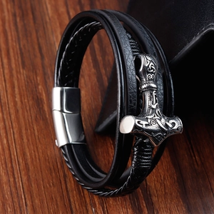 Macro shot of Viking Mjölnir pendant on a multi-layer black braided leather bracelet