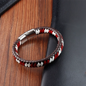 Détail du bracelet en cuir tressé avec accents rouges et fermoir magnétique argenté