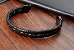 Detail of black woven leather men's bracelet with brown stitching and matte black clasp