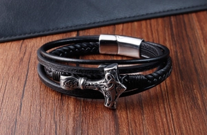 Macro detail of men's leather Viking bracelet with silver Thor's hammer and magnetic clasp