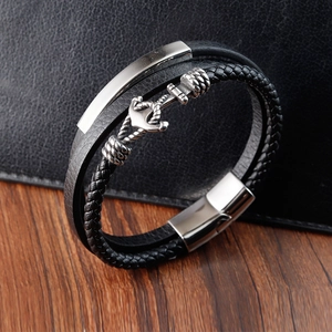 Men's multilayer leather bracelet with silver anchor and magnetic clasp on dark wood