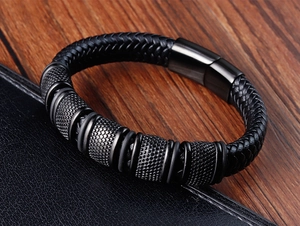 Detail of hand-woven black leather bracelet with textured metal beads and magnetic clasp