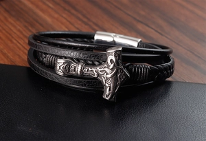Detailed close-up of multilayer leather bracelet with a vintage Viking Mjolnir pendant