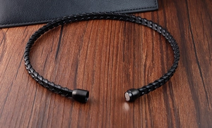 Détail d'un bracelet en cuir tressé noir avec un fermoir magnétique cylindrique élégant