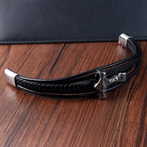 Detailed macro view of black leather woven bracelet with silver Mjolnir Viking pendant