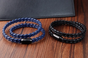 Détail de bracelets en cuir tressé avec fermoir magnétique mat sur bois