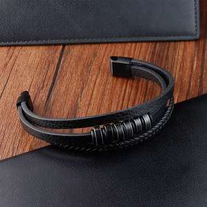 Detalle de pulsera de cuero negro multicapa con cuentas vintage y cierre de metal mate