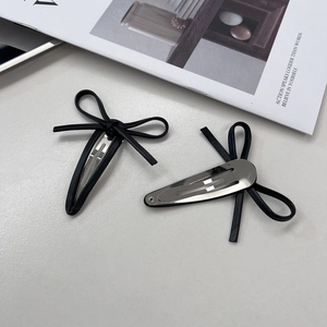 Pair of stylish black faux leather bow hair clips with silver metal BB base for women