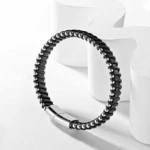 Detailed view of woven black leather bracelet with silver beads and magnetic steel clasp