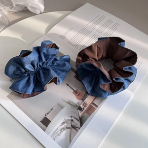 Set aus zwei Jeansblauen Haargummis mit braunem Futter auf einem Magazin