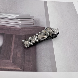 Detail of luxury hair clip with grey crystals, silver pearls and With Love heart charm