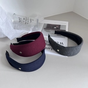 Three minimalist wide fabric headbands in burgundy, navy, and grey with gold button detail