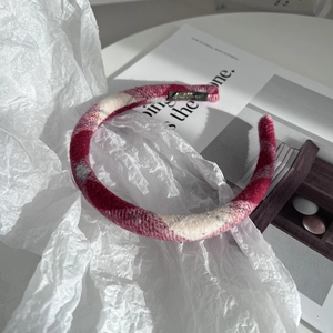 Détail d'un serre-tête en tissu à carreaux rouge et blanc avec texture en laine de qualité