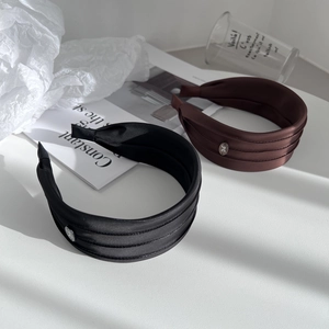 Detail of satin wide headbands with silver metal buckle featuring bow design