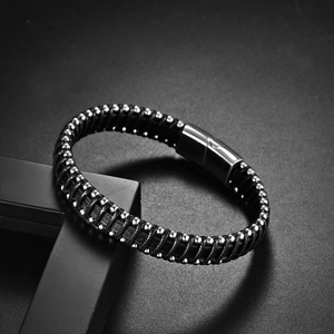 Macro detail of braided leather bracelet with silver beads and magnetic metal clasp