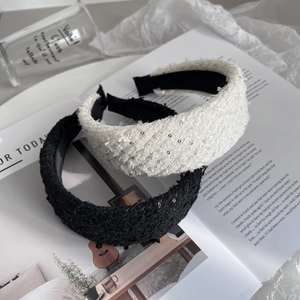 Elegant black and white tweed headbands with sequins in a stylish French lifestyle setup