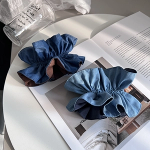 Nahaufnahme von Vintage-Jeans-Scrunchies in Hell- und Dunkelblau mit Rüschenrand