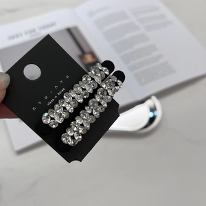 Détail de deux pinces à cheveux de luxe avec strass brillants sur base en métal noir
