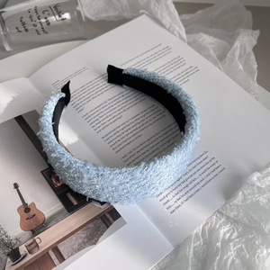 Detailed close-up of light blue tweed headband showing premium woven texture and fringe trim
